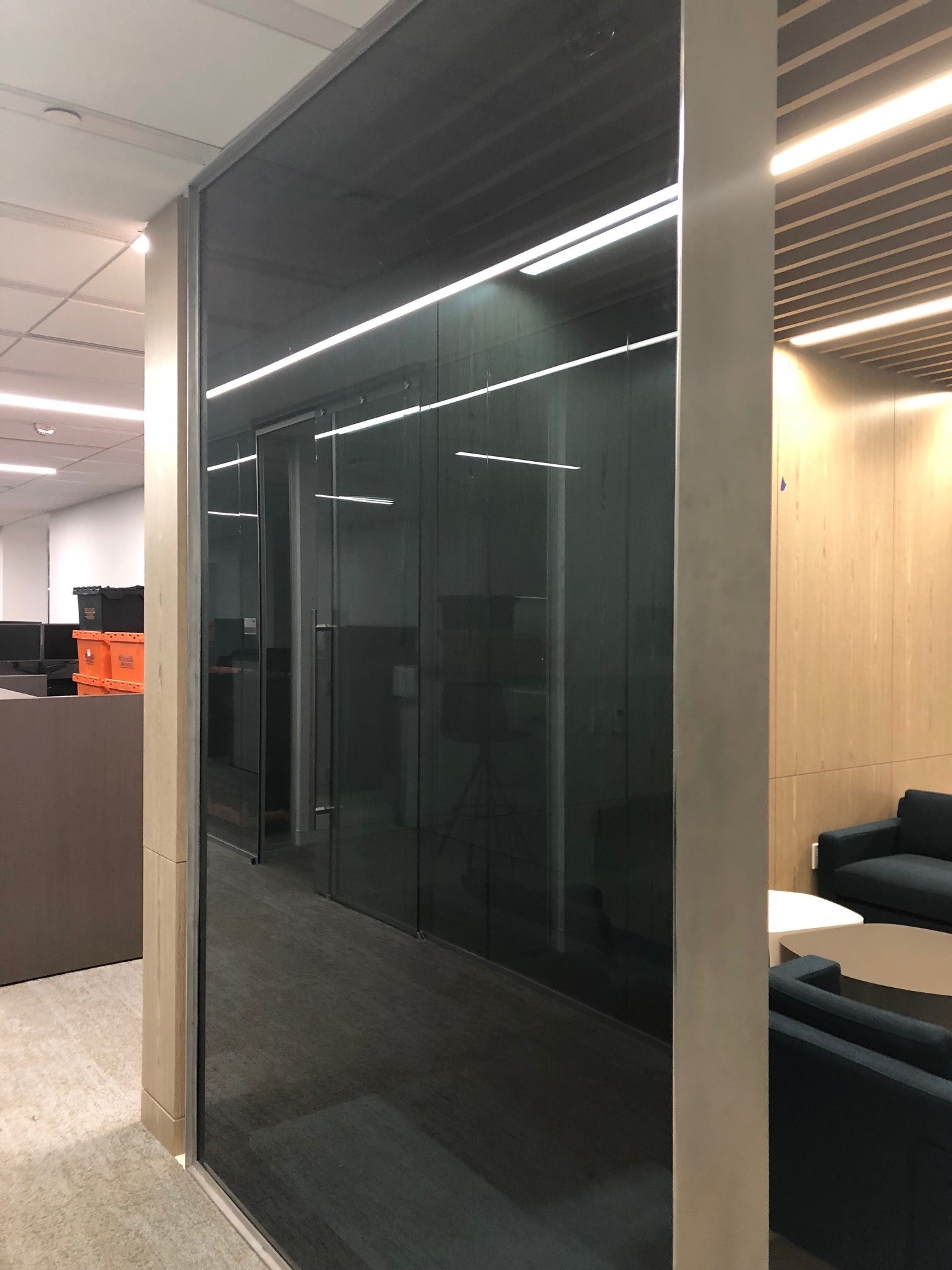 Tinted glass office partition with reflections