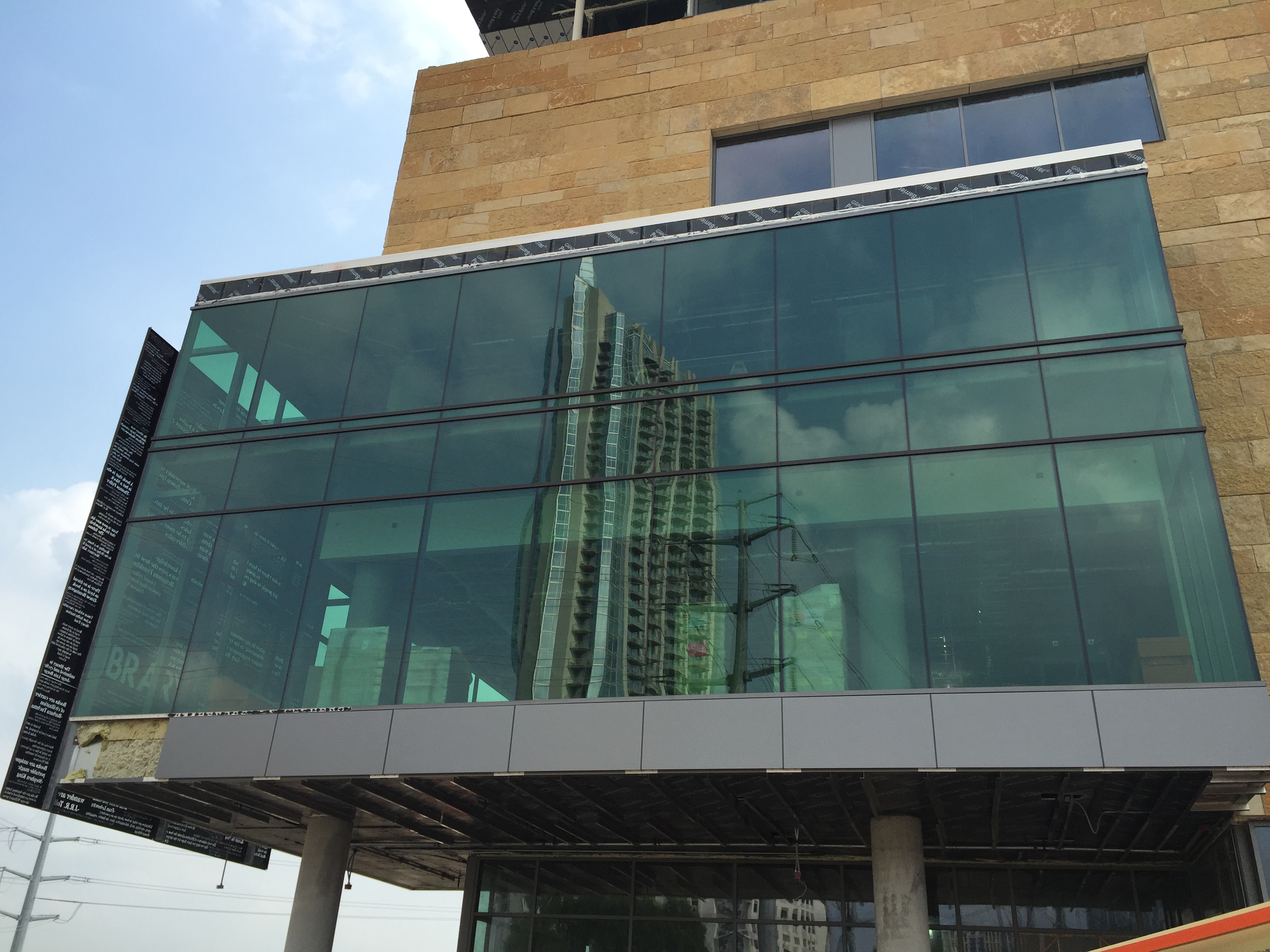 Modern building with reflective glass panels under a clear sky.