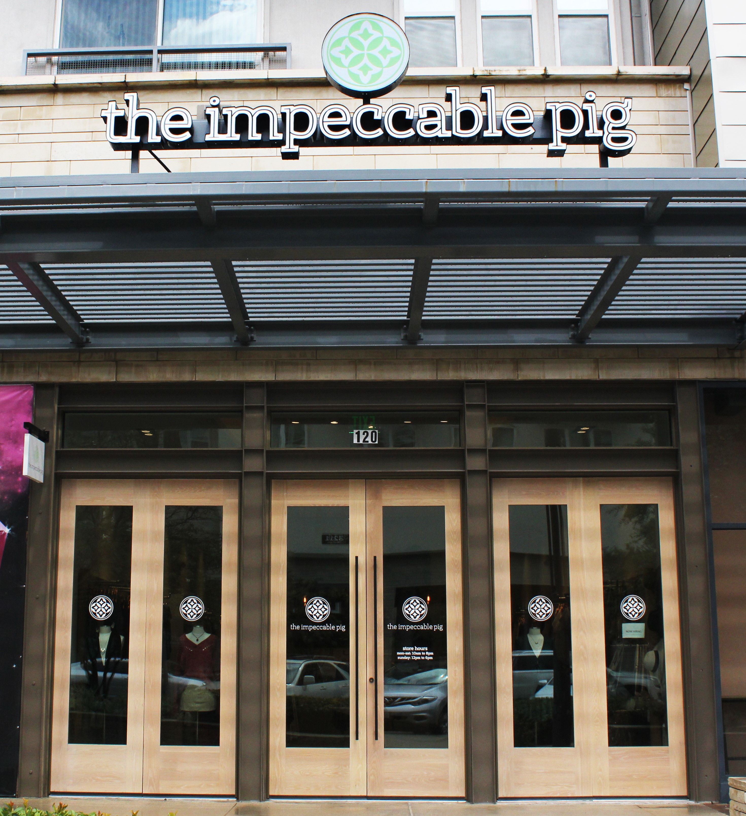 Exterior of The Impeccable Pig restaurant with wooden doors and logo.