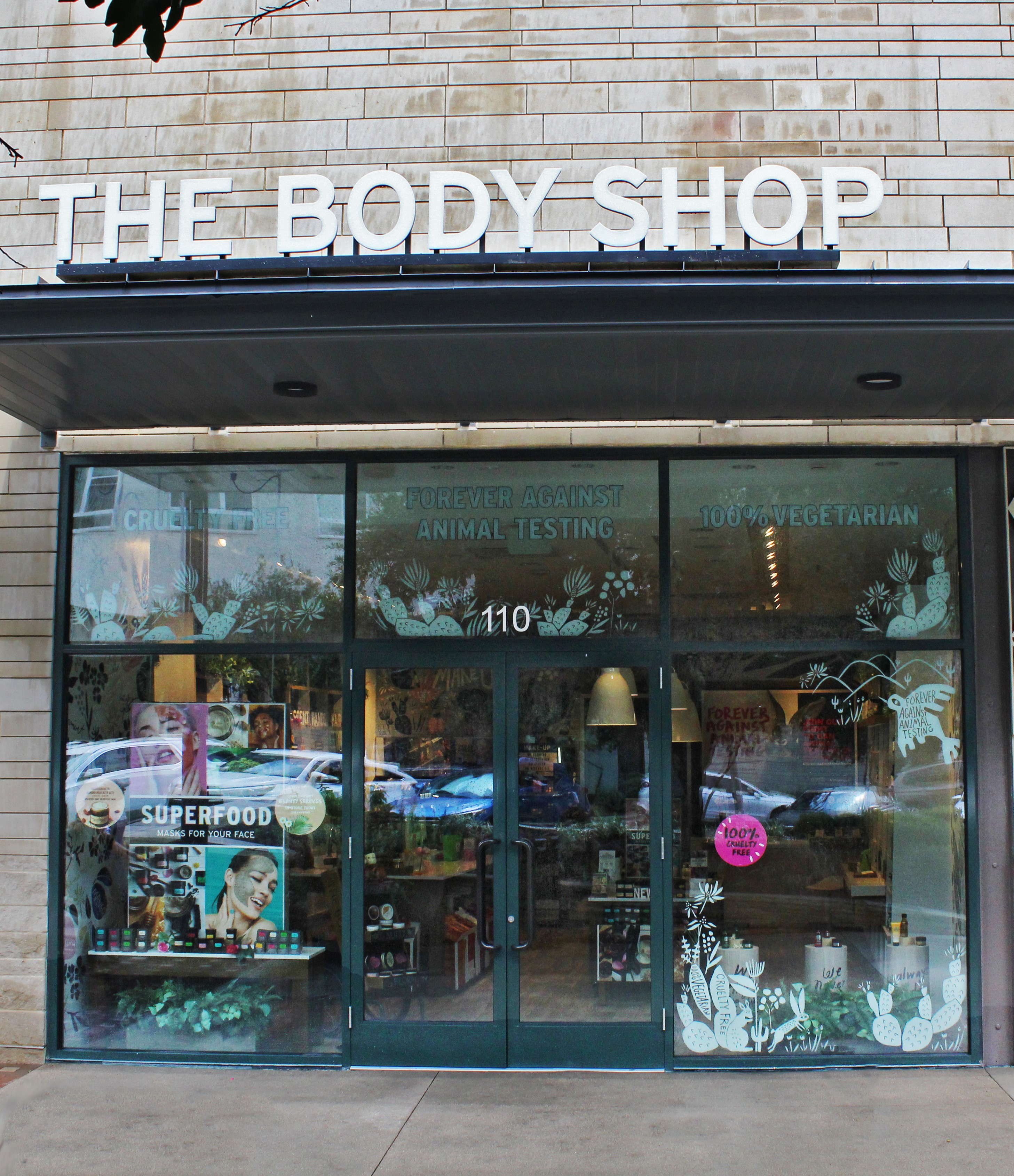 The Body Shop storefront with holiday decorations and signage.