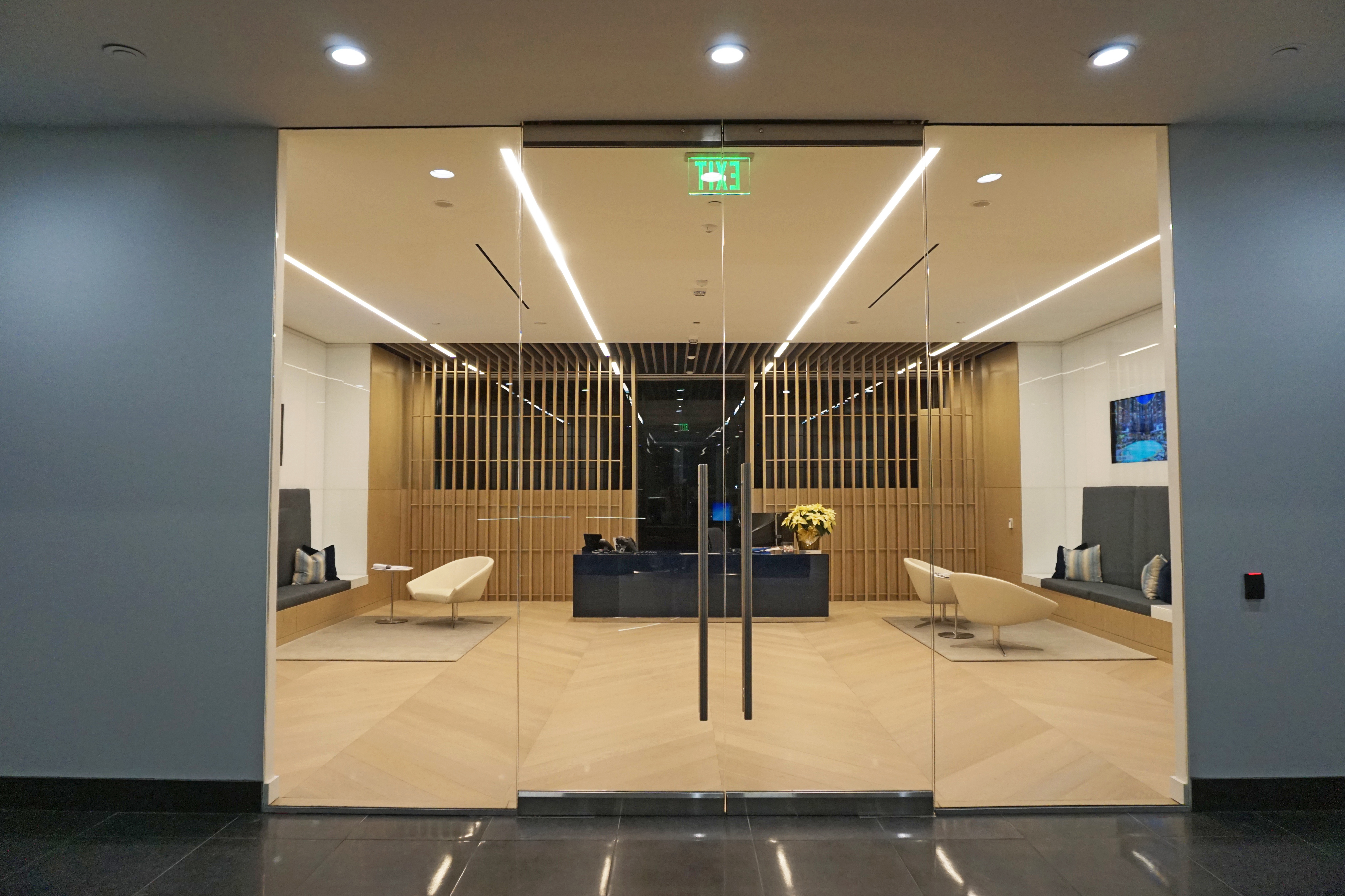 Modern office lobby with glass doors and minimalist seating.