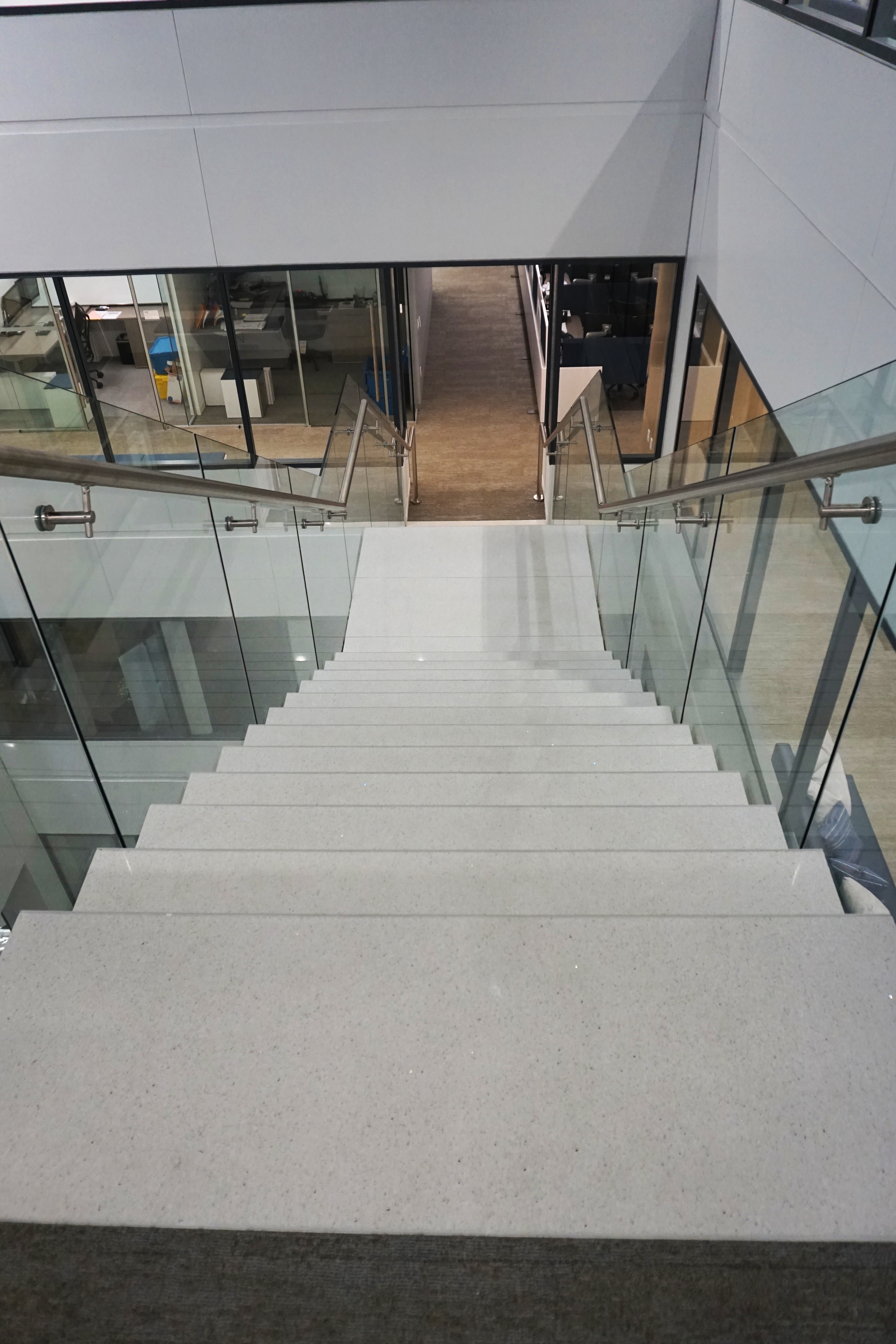 Modern glass and stone staircase in a commercial building.