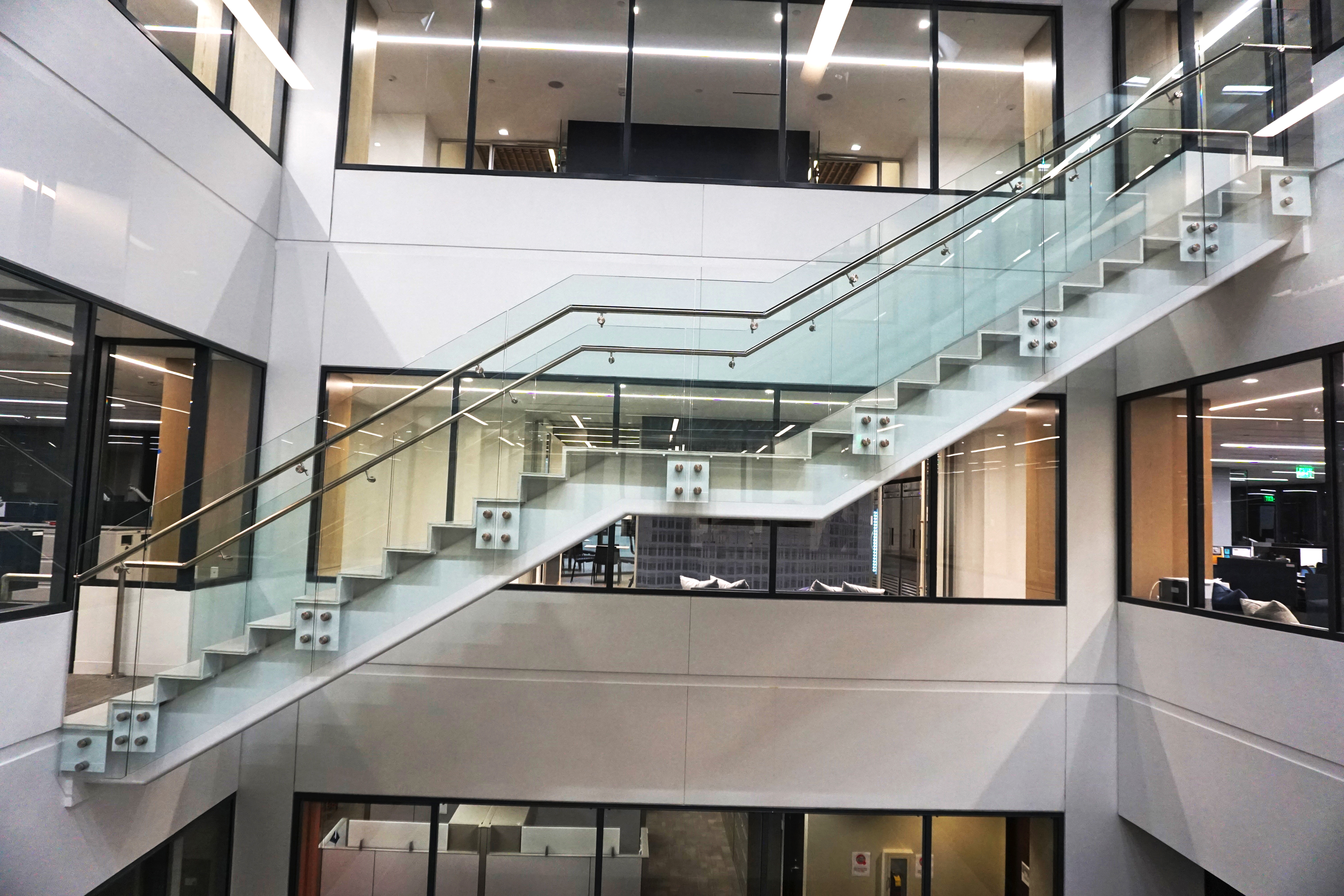 Modern glass staircase inside a building with white walls.