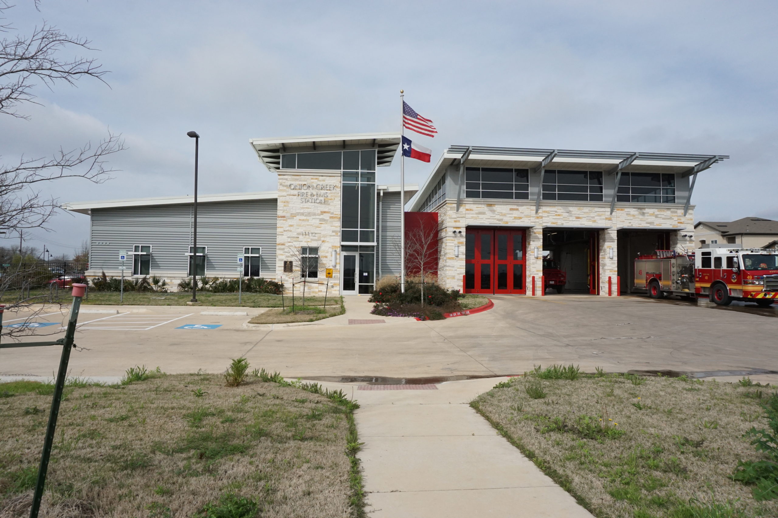 Modern fire station building with American and state flags.